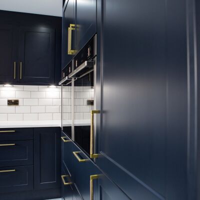 dark blue cupboard and white worktops close up details of a kitchen for brand photography