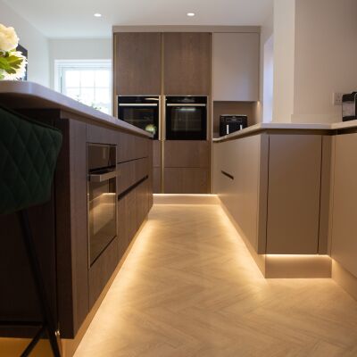 brown kitchen with lights under the cupboard to light the floor.