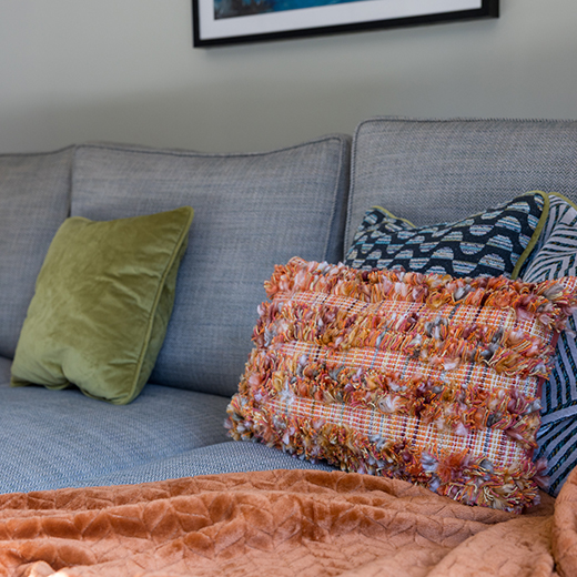 Porange cushion on a grey sofa photography for an interior designer
