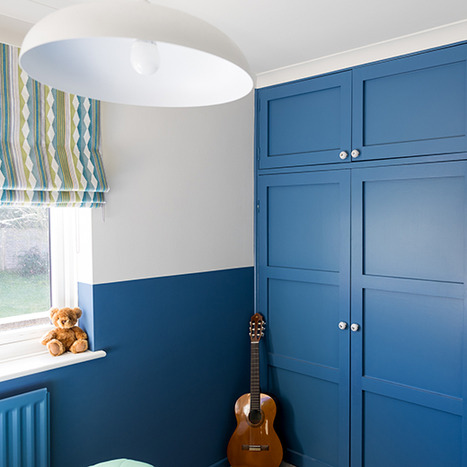 interior deign photography of a blue wardrobe and green and blue patterned blind