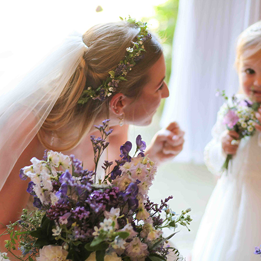 bride looking at her flower girl and smiling in her wedding photoraphy