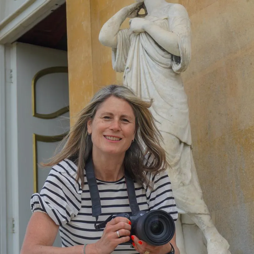 Professional portrait of Becky Kerr, brand photographer, with camera outside building in Bedfordshire