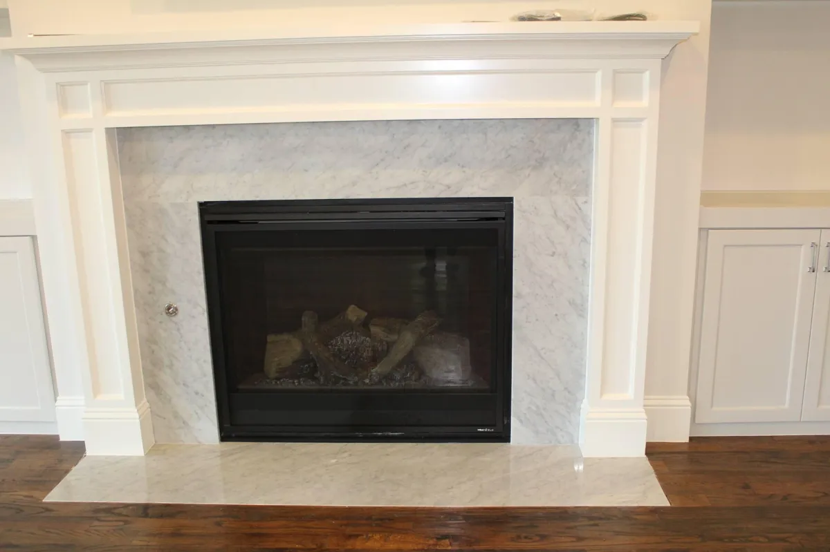 Carrara marble fireplace surround installation by Dallas Granite Installers in a Dallas TX luxury home