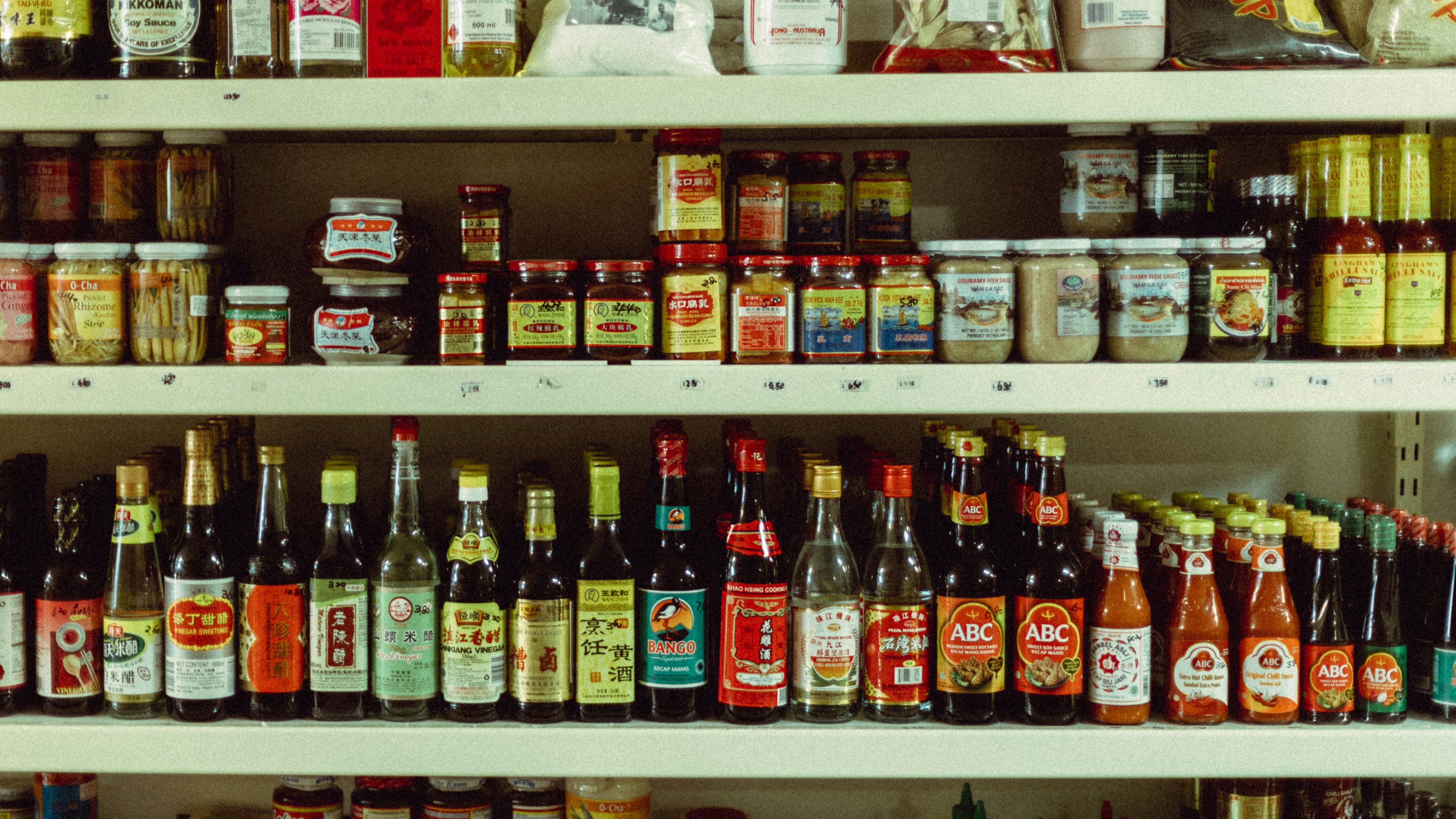 A grocery shop with people and a motorcycle outside.