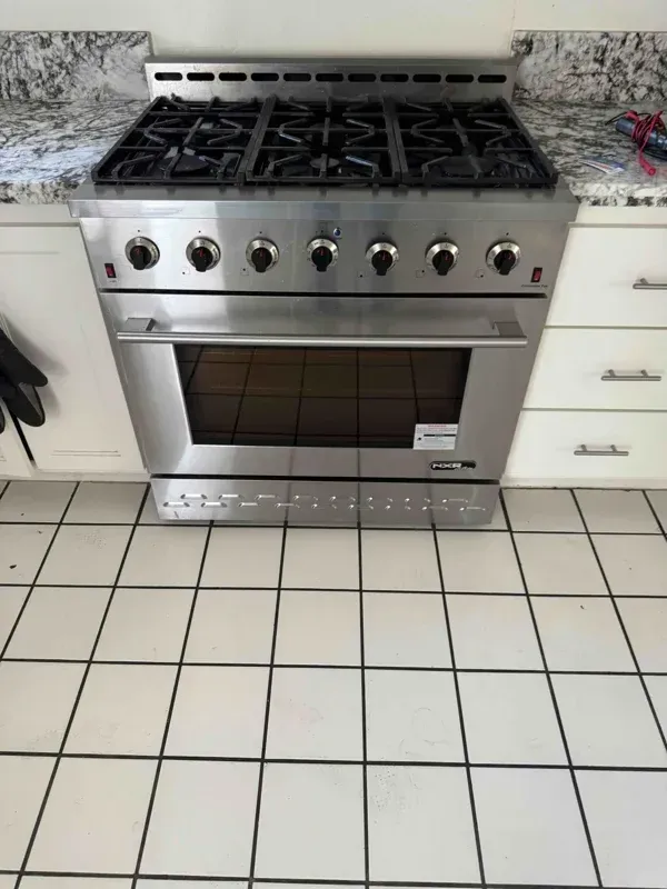 Gas slide-in range and oven unit being serviced by a professional technician in Fresno, CA near the Woodward Park area.