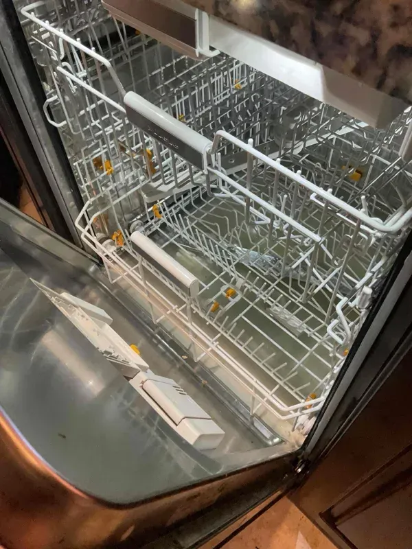 A certified home appliance technician using diagnostic tools on a kitchen unit in Visalia, CA near Mooney Boulevard.
