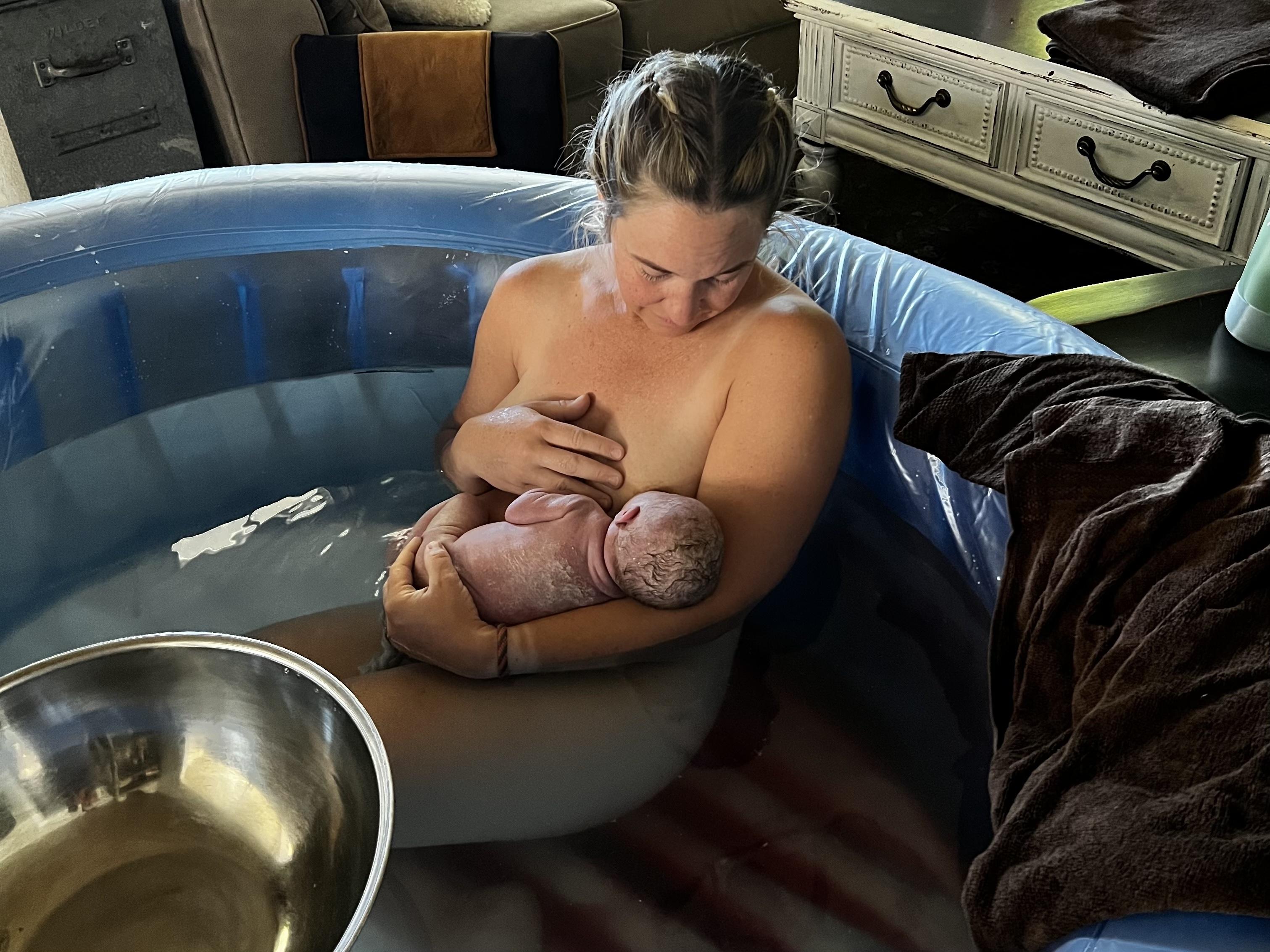 Britni water birth holding a baby