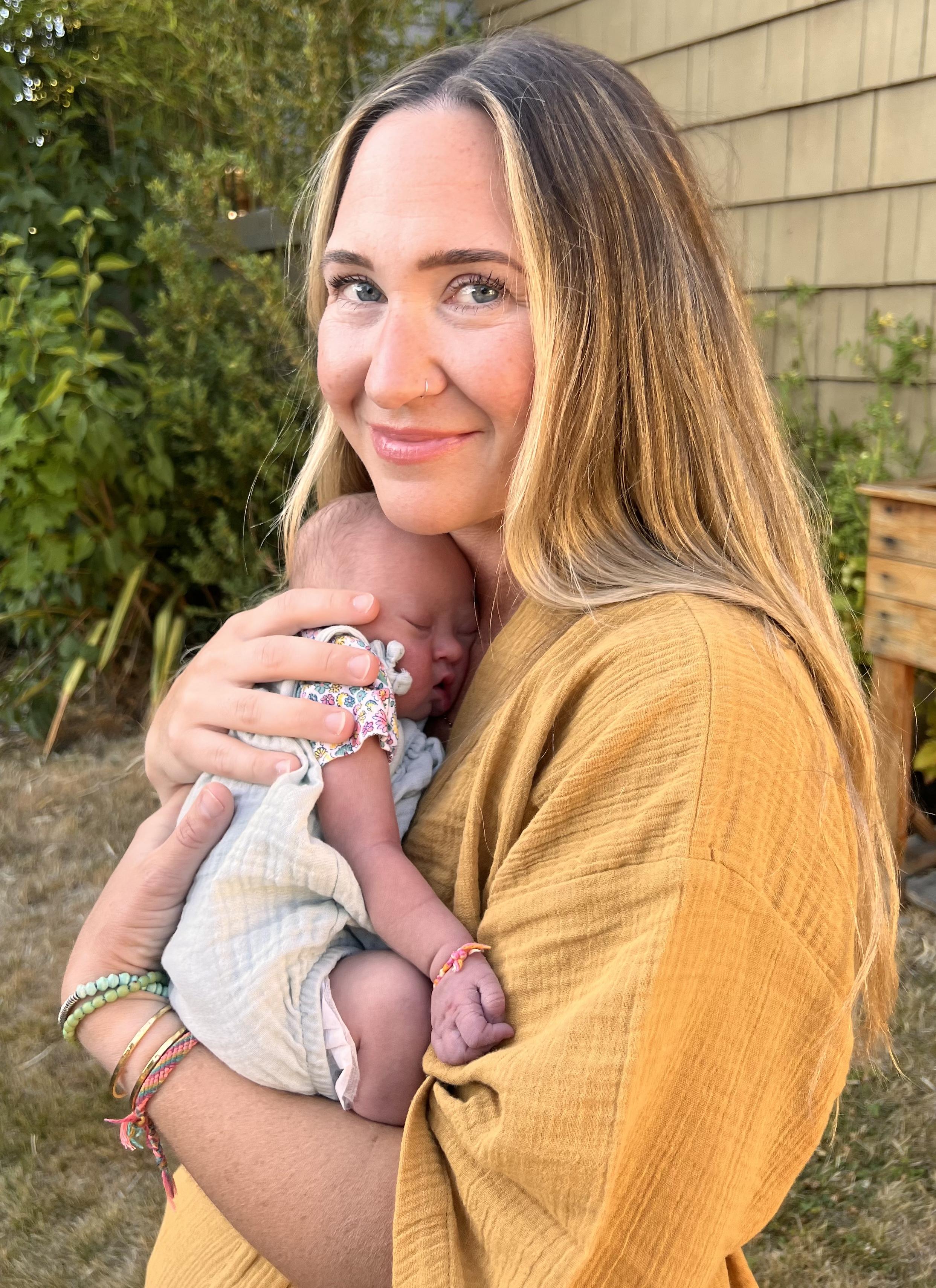 Britni holding baby wearing yellow tunic