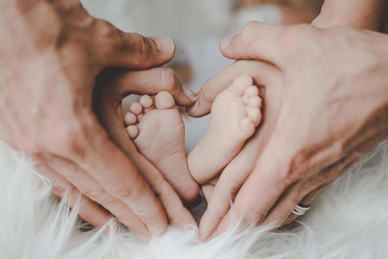 baby feet with mom and dad hands