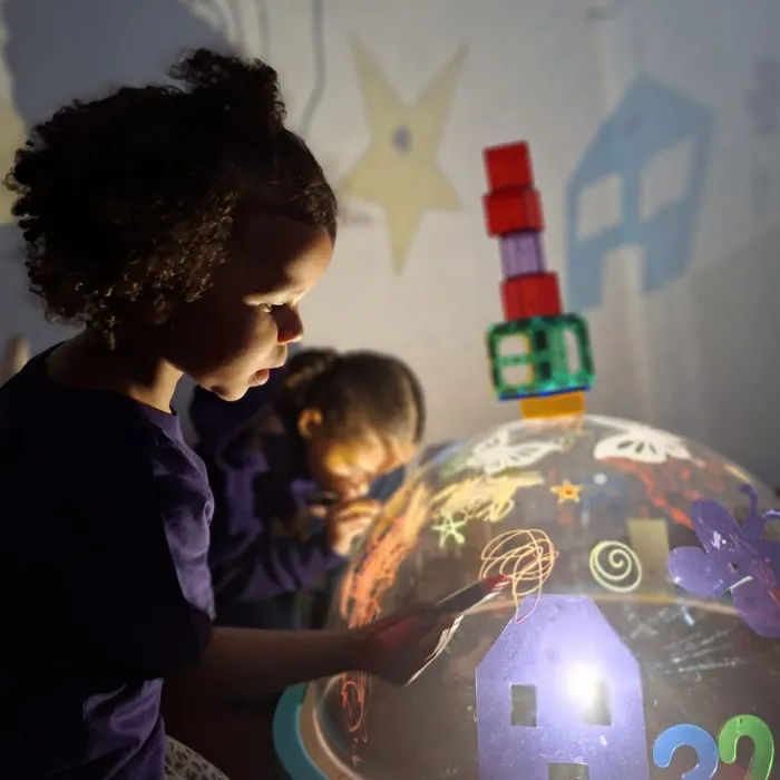 Children engaged in creative play with light exploration and colorful building blocks at Curious Minds Early Years Academy, Horizon West, inspired by the Reggio Emilia approach