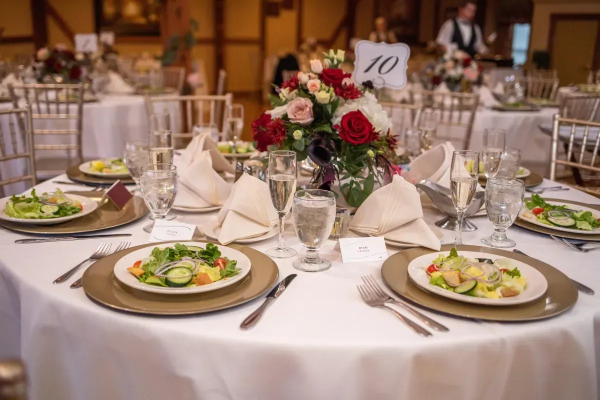 Wedding reception setup at Morningside Inn featuring a sweetheart table with floral arrangement, gold chiavari chairs, and panoramic views of rolling hills