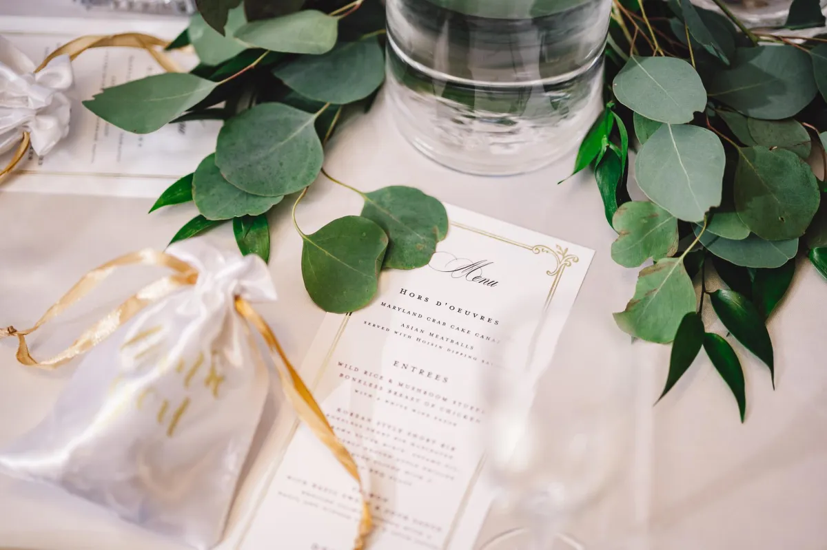 Elegant wedding reception table at Morningside Inn with printed menu, greenery centerpiece, and thank-you favor bag