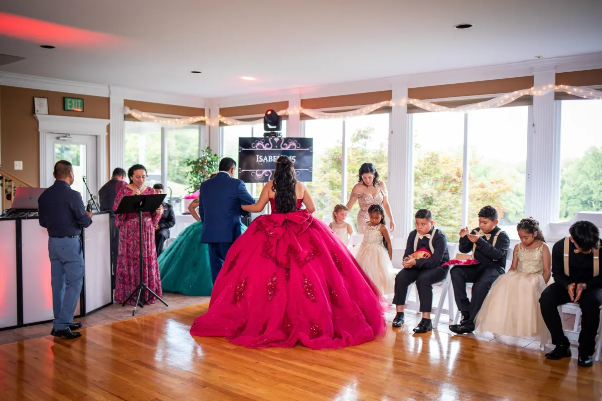 Bride and groom giving a wedding toast at Morningside Inn, standing behind a floral-covered sweetheart table with scenic pond views through large windows