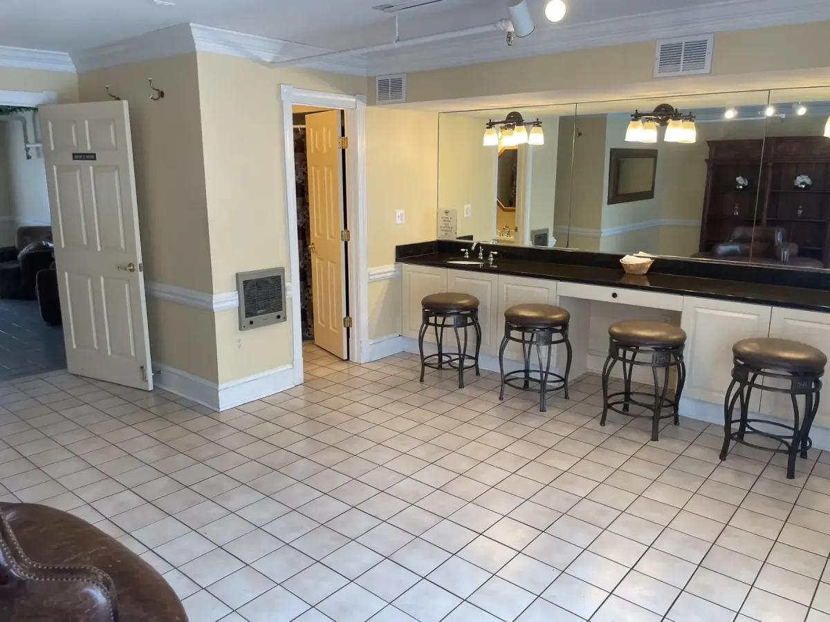 Spacious bridal suite at Morningside Inn in Frederick, Maryland, featuring a long vanity with stools, large wall mirror, and natural lighting—ideal for wedding day preparations.