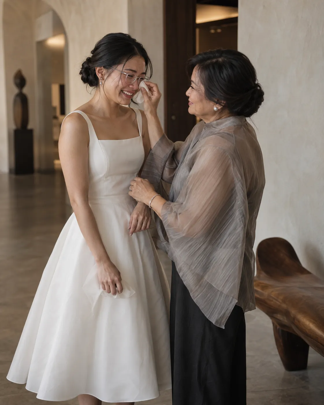 Southeast Asian bride wearing glasses sharing an emotional moment with her mother.