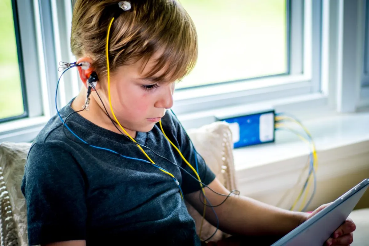 A boy engaged in a NeurOptimal® neurofeedback session, focusing intently on a brain training exercise.