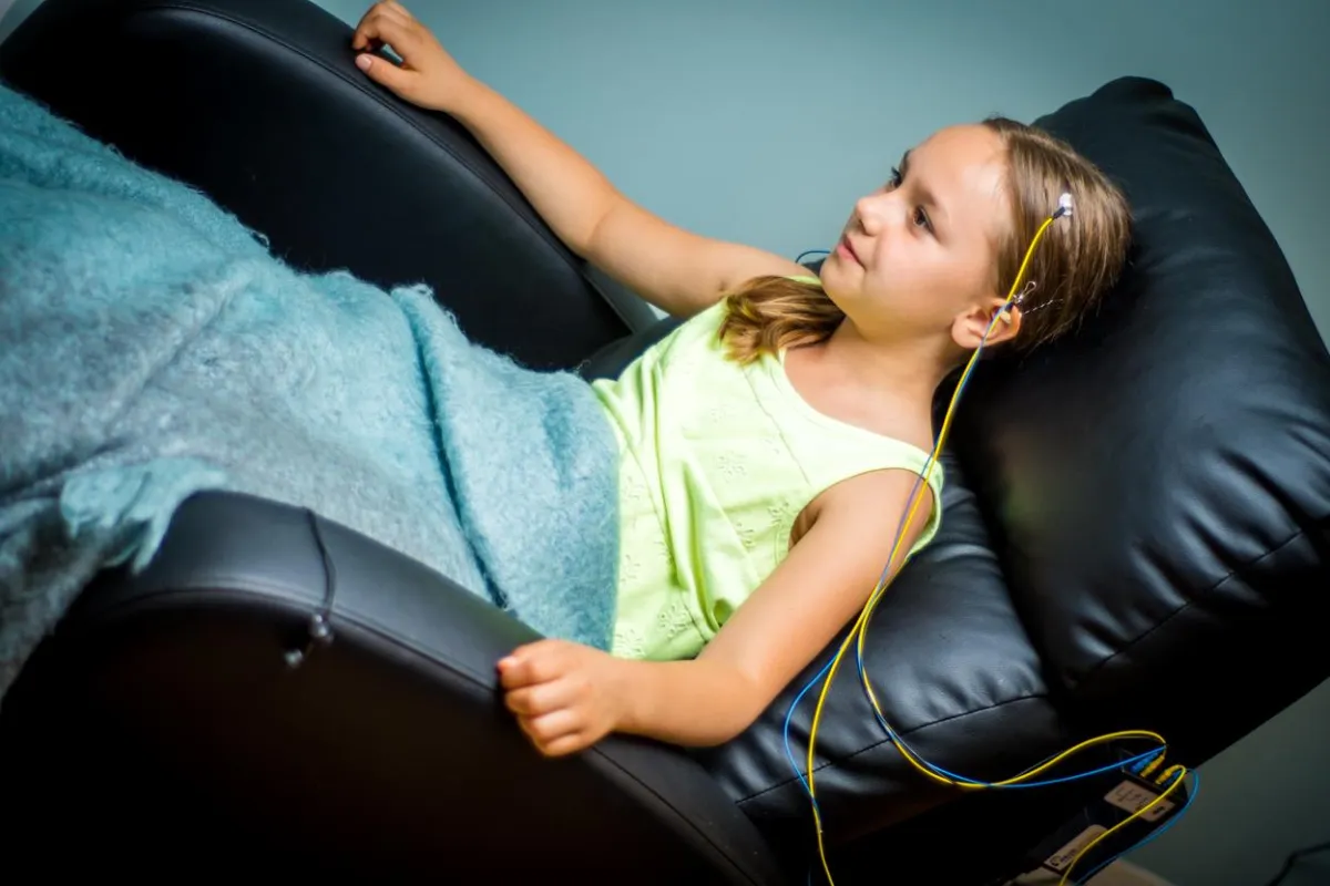 a young girl engaging in an at home neurofeedback session while reclining in a comfortable chair