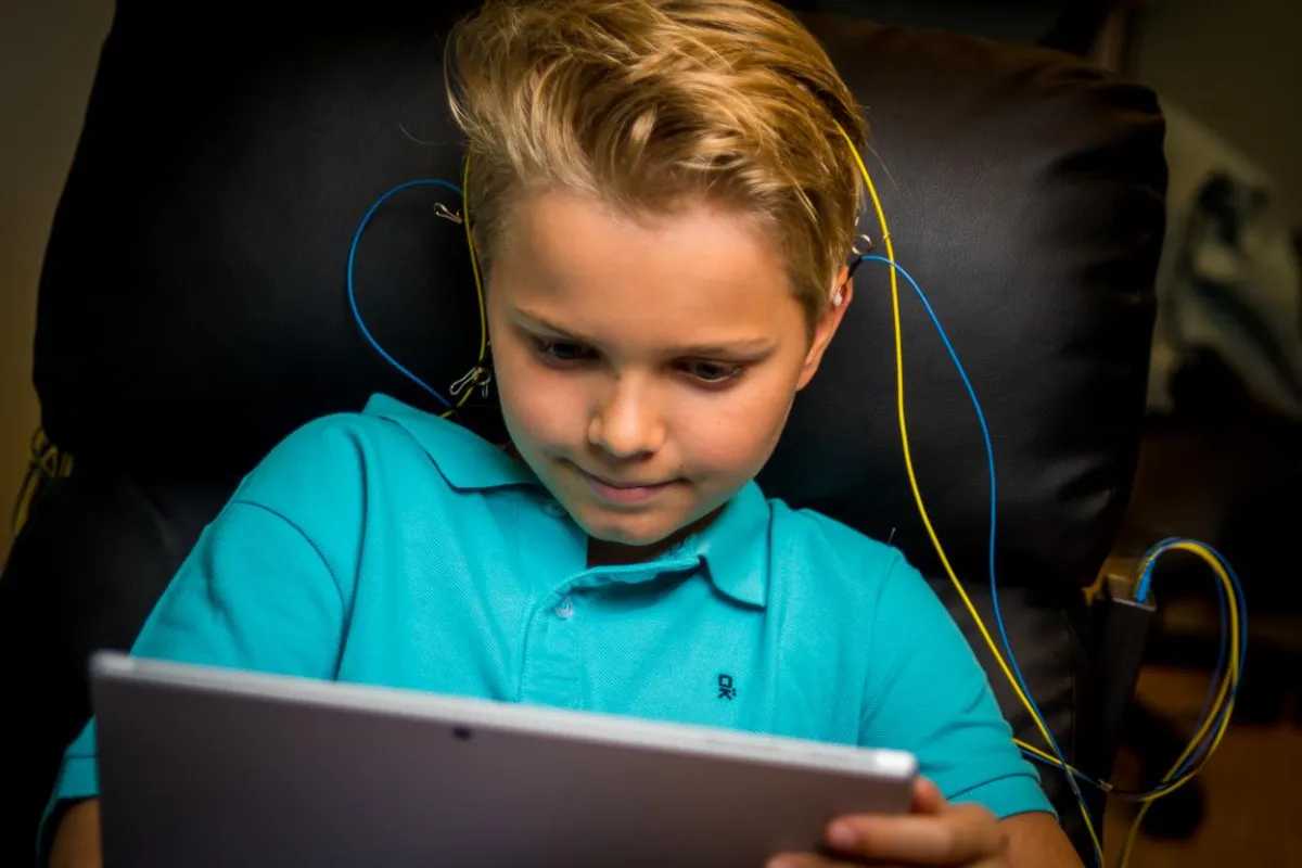 A boy engaged in a NeurOptimal® neurofeedback session, focusing intently on a brain training exercise.