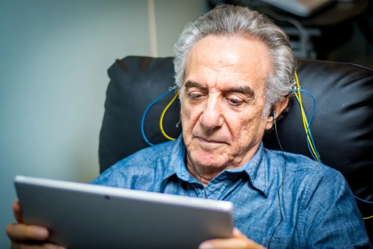 An elderly man focusing on an at home neurofeedback brain training session