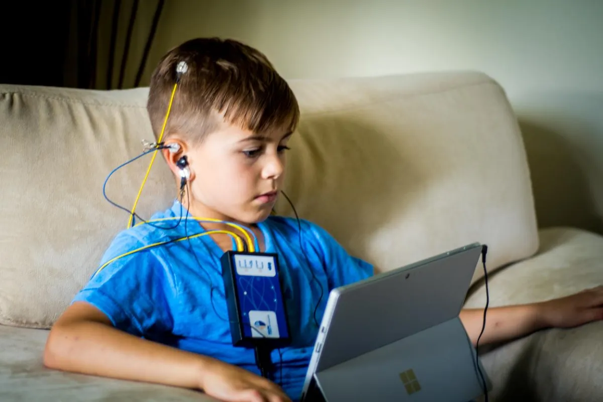 a boy engaging in a neurofeedback session on a comfortable couch