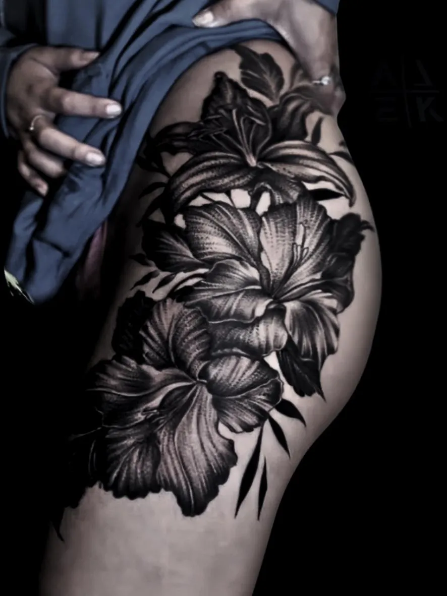 “Blackwork floral thigh tattoo with whip shading, featuring bold flowers and smooth gradients by Alek the Saint, Point Loma, San Diego.”
