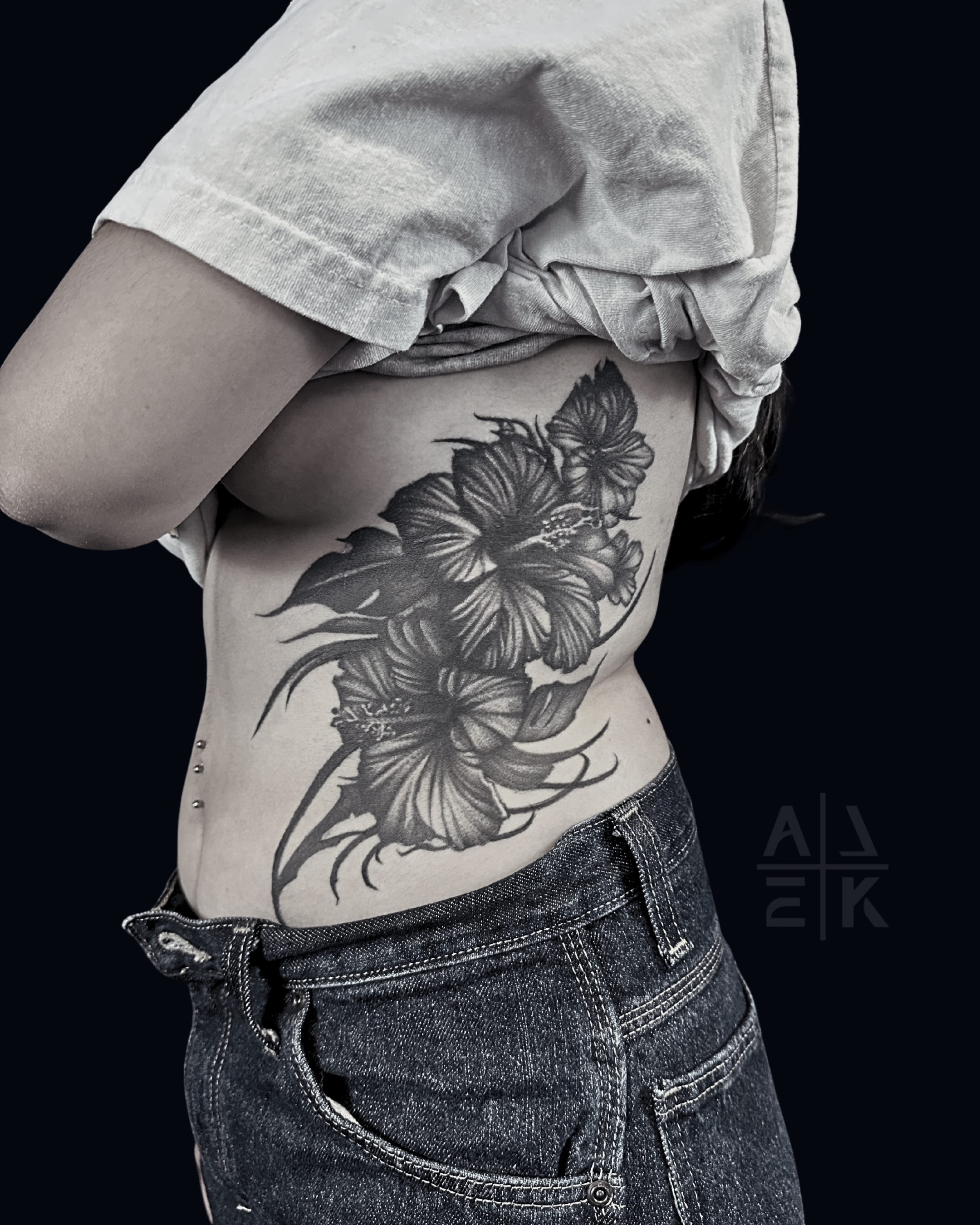 Black and grey floral tattoo with detailed shading on the side rib and waist, tattooed by Alek the Saint at San Diego Tattoo Company in Pacific Beach, San Diego