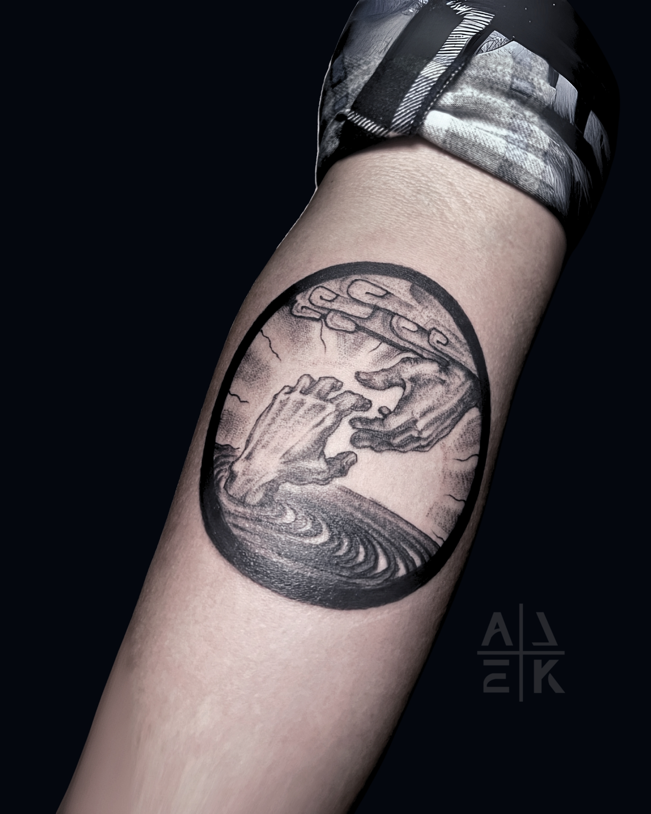 Black and grey circular tattoo inspired by classical hands with soft shading and bold black border on the calf, tattooed by Alek the Saint at San Diego Tattoo Company in Pacific Beach, San Diego