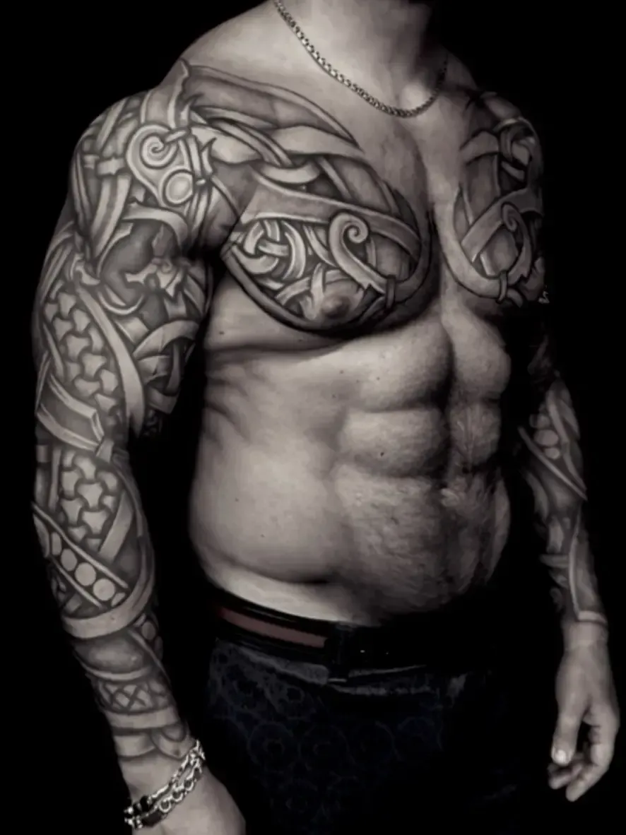 Viking blackwork tattoo covering chest and both sleeves, featuring Nordic knotwork and armor-pattern linework by Alek the Saint, Oceanside, Ca