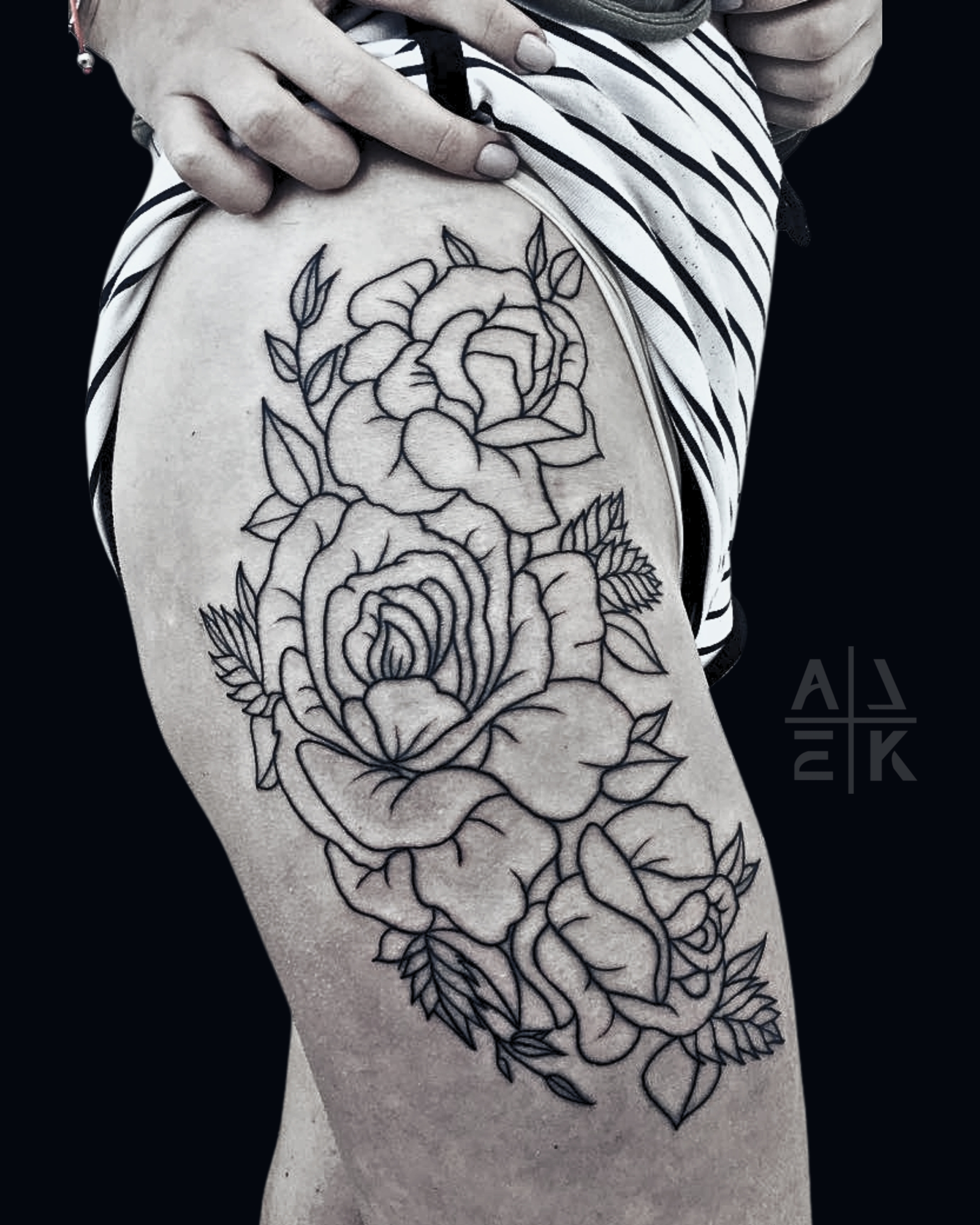 “Blackwork floral thigh tattoo with whip shading, featuring bold flowers and smooth gradients by Alek the Saint, Oceanside, Ca”