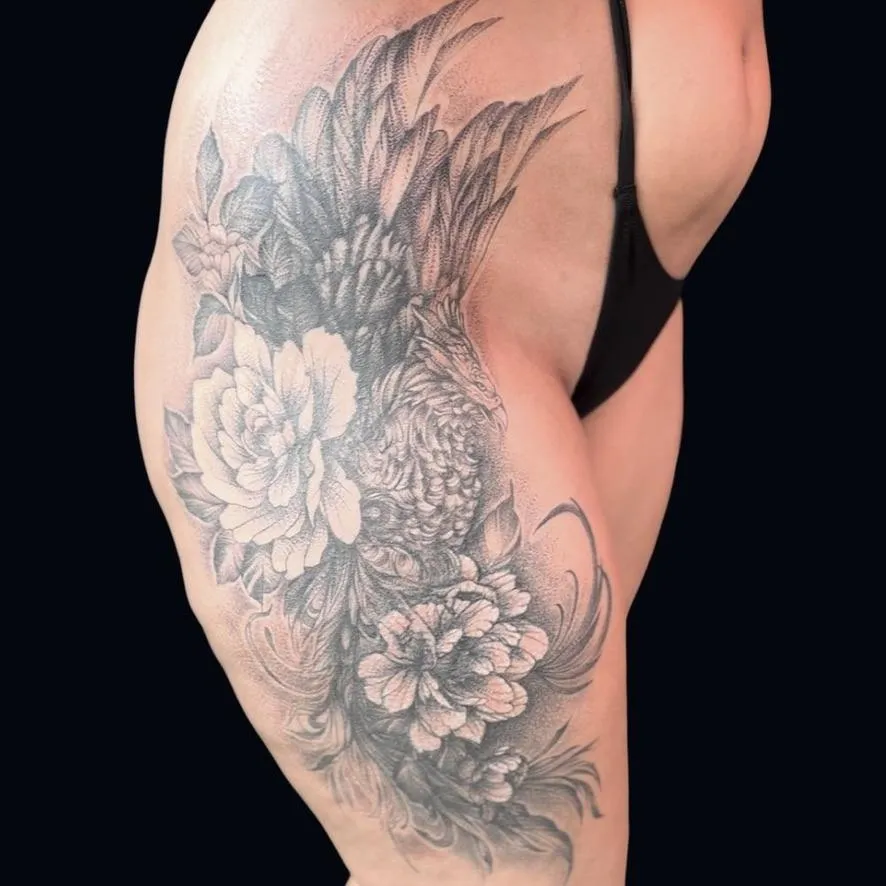 blackwork Phoenix tattoo with peonies on the hip in Oceanside, California