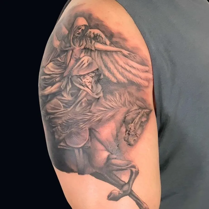 A black and gray tattoo of winged Horseman a cover-up on the shoulder and Oceanside, California