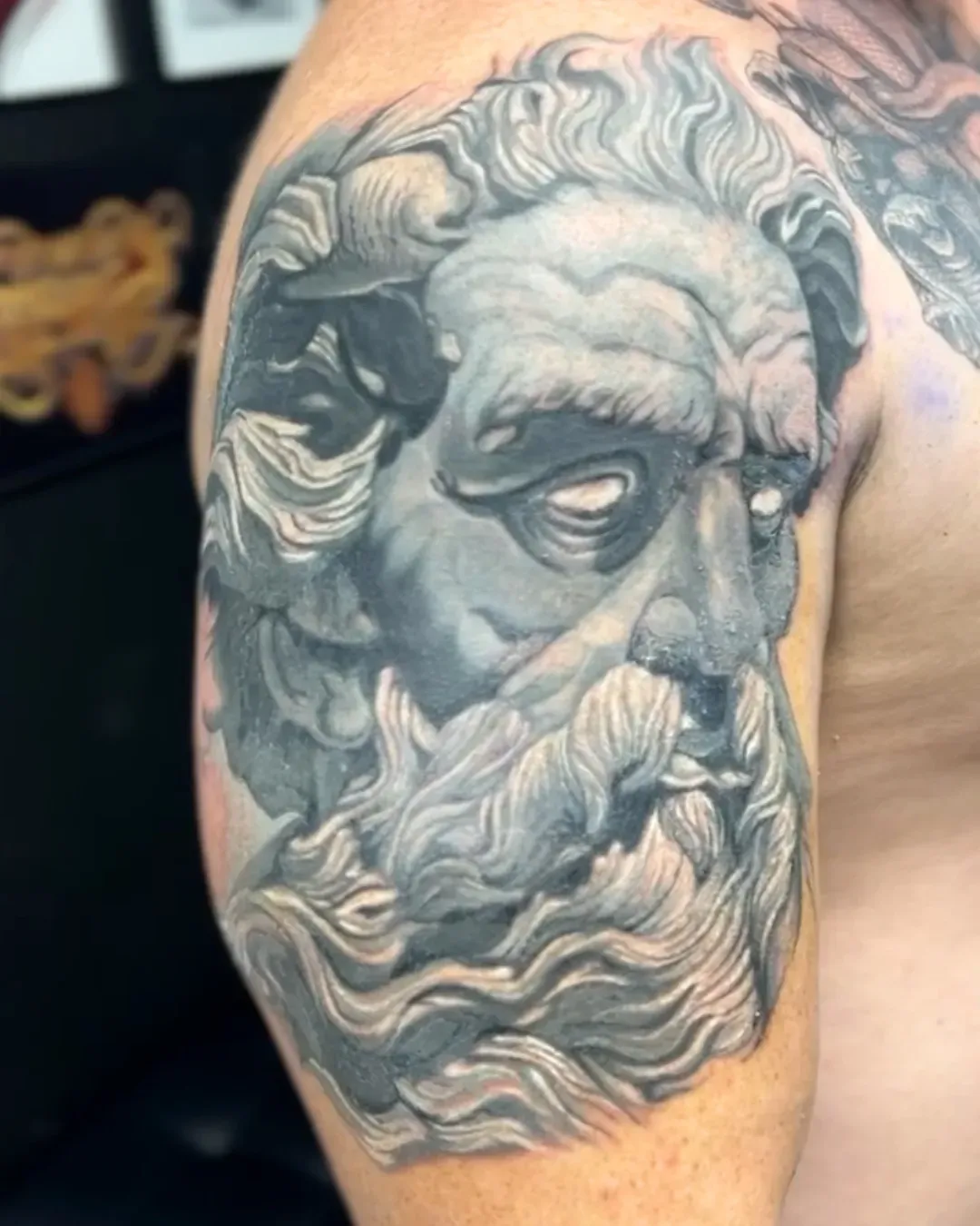  a cover-up of a tribal tattoo that is now a tattoo of Poseidon's face. statue was very large.done in bluish grey tones by Alek the Saint in Oceanside Ca 