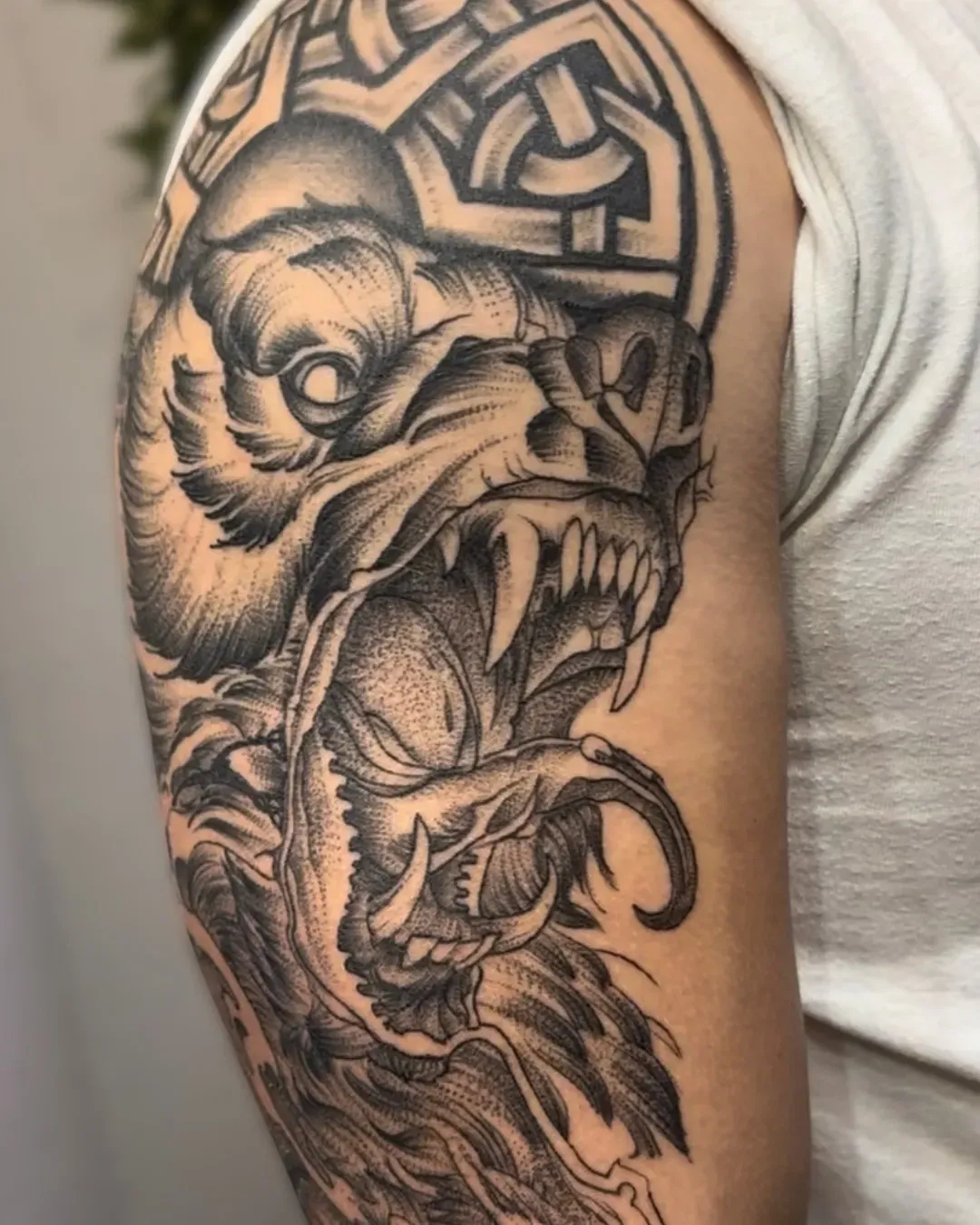 Black work, bear tattoo on the shoulder with Viking ornaments done by the Saint in Oceanside, California