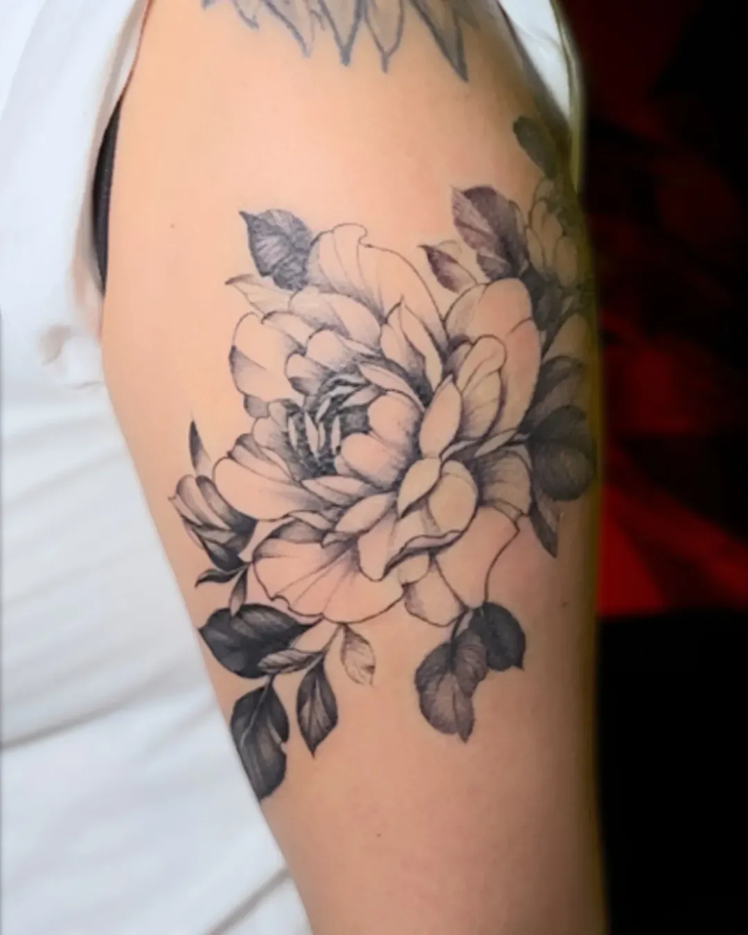 done by Alek the Saint  tattoo artist in Oceanside, California A black work floral tattoo of a peony on the shoulder
