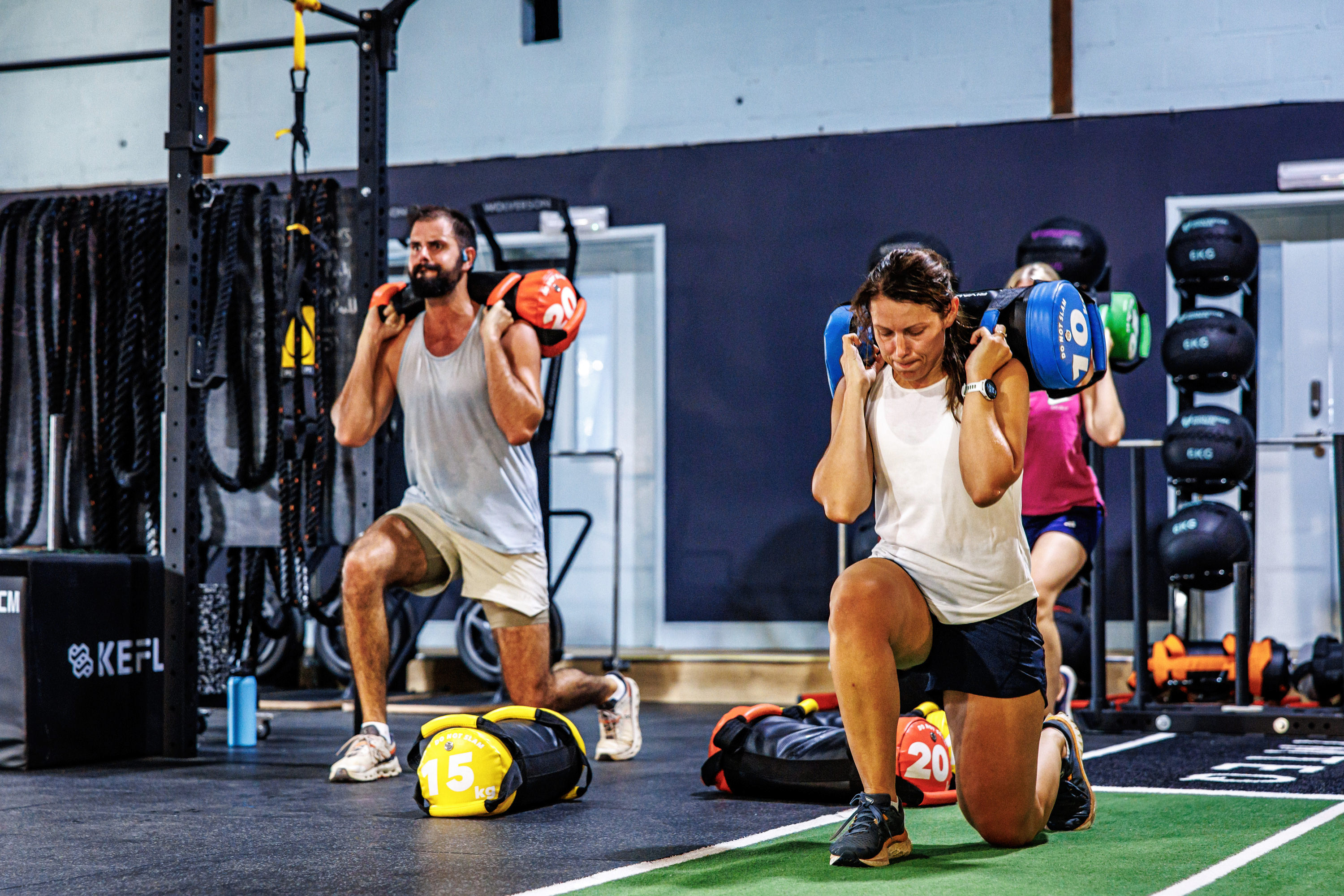 Two people working out, one on a rowing machine