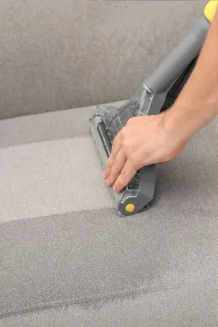 Close-up of a professional cleaner using a specialized tool to clean upholstery, showcasing the thorough upholstery cleaning services offered by Right Now Cleaning Services in Sydney.