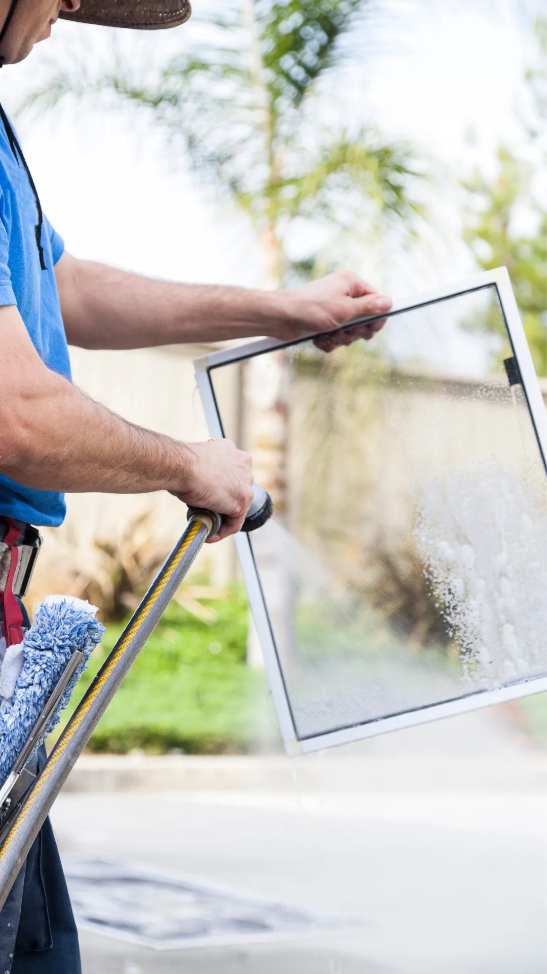 A professional cleaner using a hose to thoroughly clean a window screen, illustrating the detailed and effective screen cleaning services offered by Right Now Cleaning Services in Sydney.