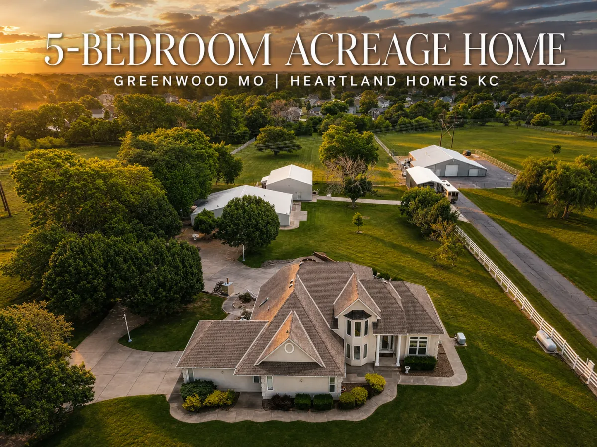 Aerial view of a 5-bedroom acreage home in Greenwood, MO, featuring expansive grounds, multiple outbuildings, mature trees, and private driveway.