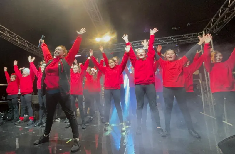 Children performing a dance routine at Huntingdon Christmas Market in red uniform