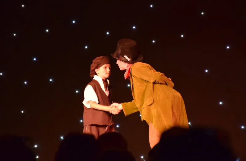 Children acting on stage in costume during a Michelle Gauci Academy drama performance