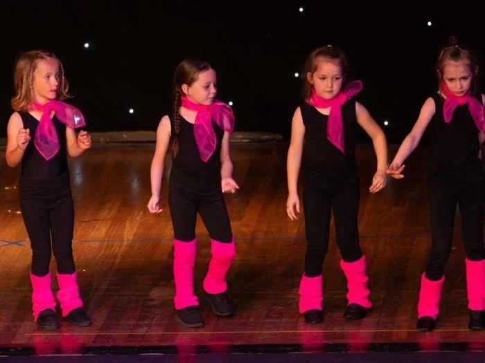 Confident young dancers in pink and black outfits performing a high-energy Teeney Boppers routine at the 2024 MGA showcase.