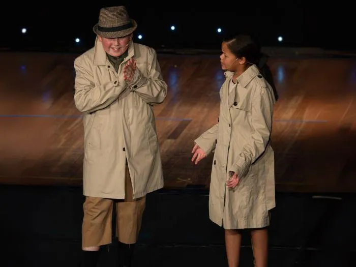 Teen performers delivering an emotional scene in trench coats at the 2024 MGA show