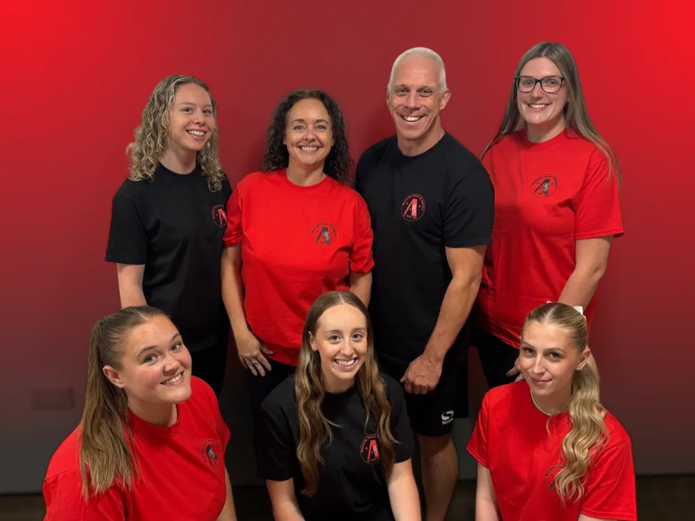 The Michelle Gauci Academy teaching team in red uniforms, dedicated to inspiring creativity and confidence in every child.