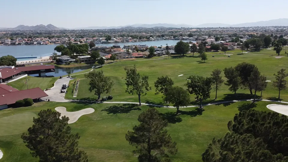 A scenic view of a golf course and mountains