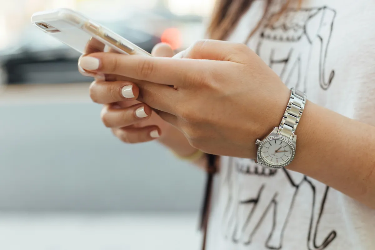 Person checking their smartphone, representing a customer receiving a review request