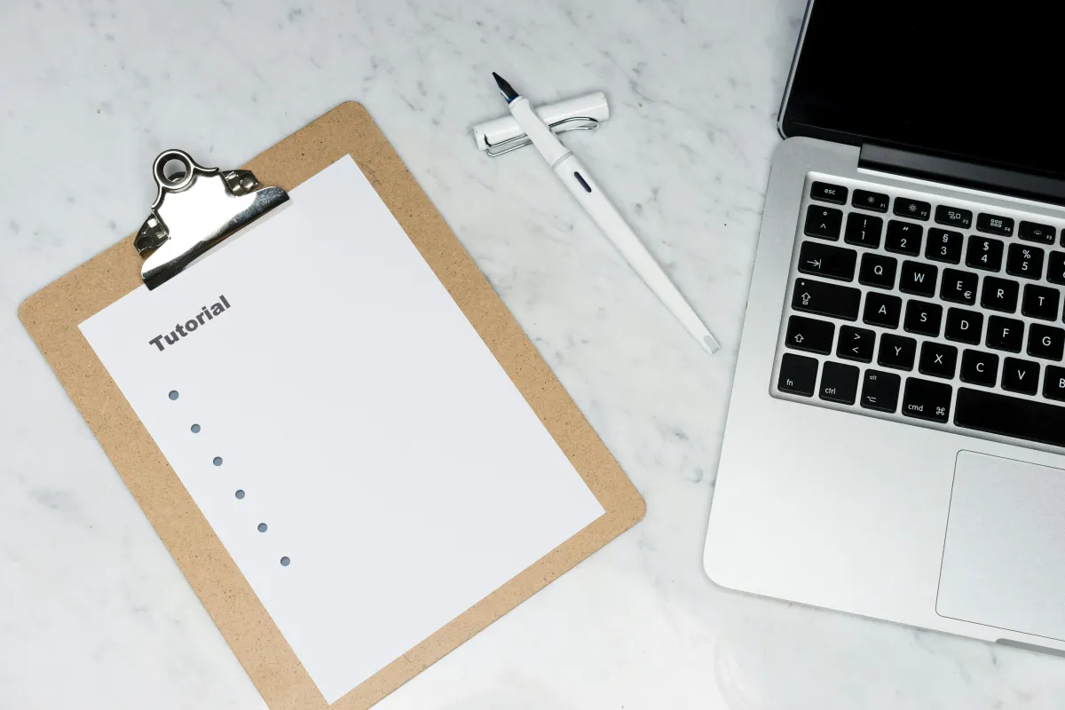 Clipboard with a checklist on a desk next to a laptop