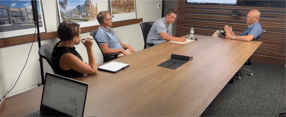 Composite showing property management professional reviewing blueprints for workforce housing development