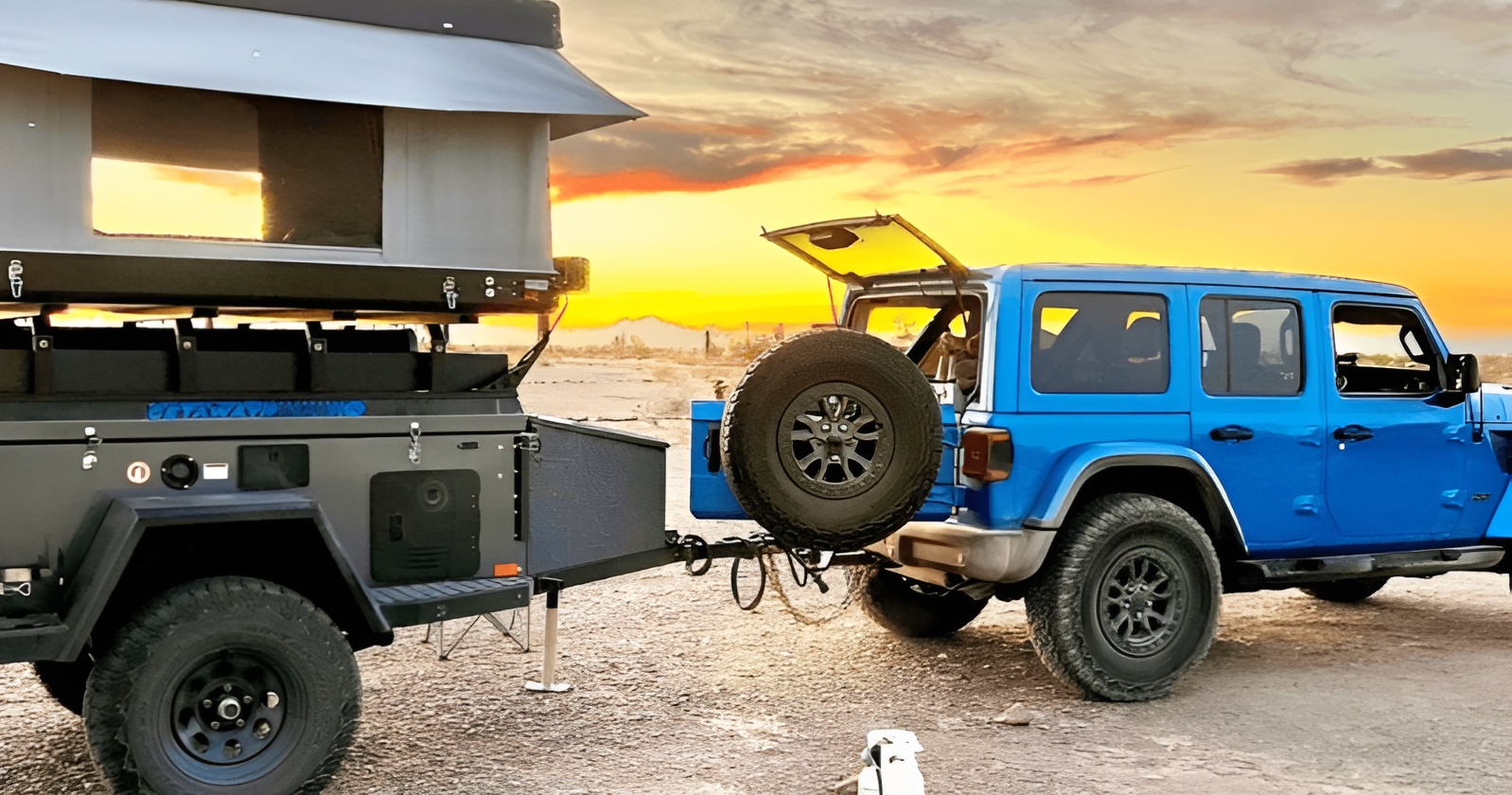 A blue Jeep towing an off-road camping trailer at sunset.