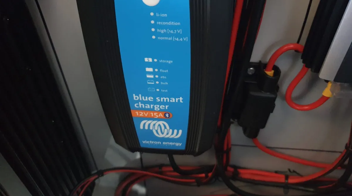 Camping trailer set up with an awning and outdoor kitchen.