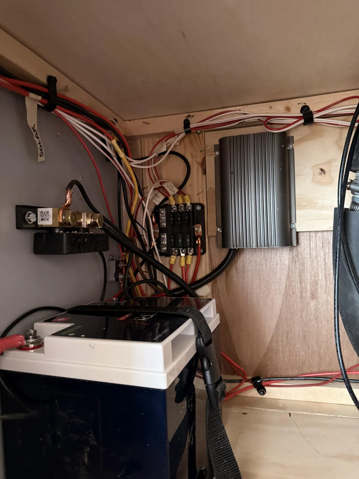 Riptide camper electrical system showing lithium battery, fuse panel, and wiring inside cabinet